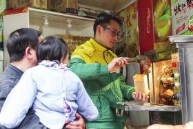 　　2月18日，长沙雨花区王公塘街，湖大毕业生孙亚明创业卖起了红薯。图/实习生徐士洁记者陈正