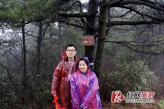 游客在“认养”的“爱情树”前合影。 肖焕 摄