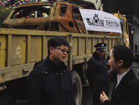 3月14日，奔驰车主龚先生拖着因为交通事故而起火烧毁的车到4S店维 权，4S店工作人员出面沟通。图/记者陈正