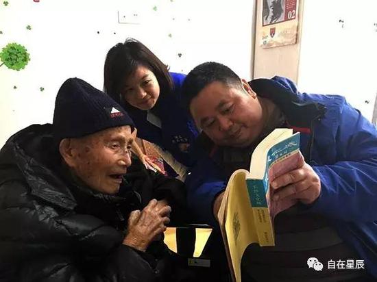 （李晓阳给抗战老兵伏笑雨看当年的旧文章。）