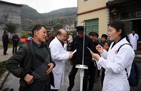 &nbsp;&nbsp;&nbsp;&nbsp;3月31日，在免费体检现场， 65岁的村民刘自强（左一）正在听昂洞卫生院院长田蕊介绍健康常识。李尕 摄
