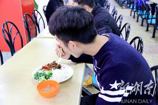 
	4月11日中午，来自城步的苗族小伙李俊在食堂用餐。
