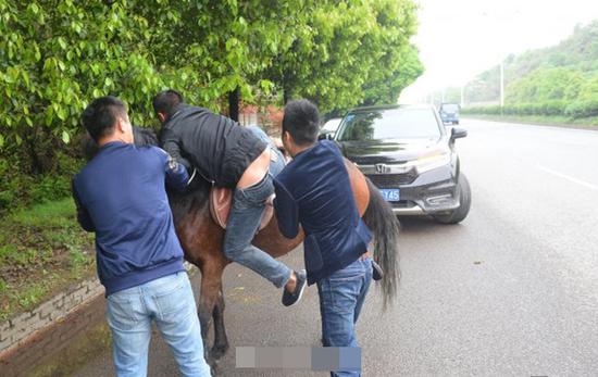 不一会儿，几名男子下车把另一名男子扶上马试骑。