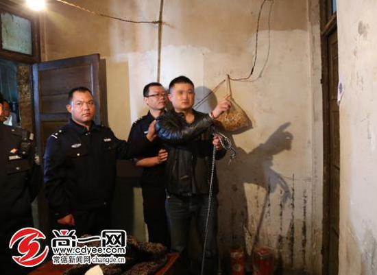 办案民警押解犯罪嫌疑人指认作案现场。尚一网通讯员 王建军 摄