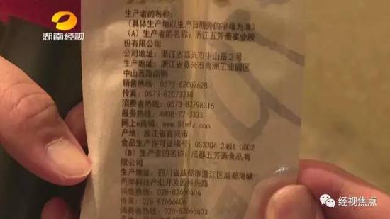 位于长沙望城区雷锋大道上的这处民房被执法车辆牢牢围住，民房的门口一辆白色货车上满载各种粽子的包装箱。