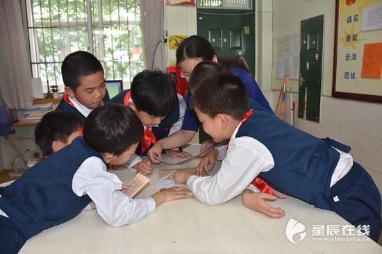 小朋友们正在阅读易炼红爷爷的回信。图片来源：实习记者高思玥拍摄。
