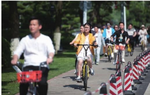4月29日,五一小长假第一天,长沙市橘子洲景区,市民骑共享单车至橘子洲大桥下,享受假日里的好天气。傅聪 摄