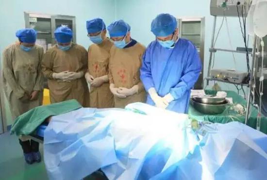 资料图:手术前医护人员向遗体捐献者默哀