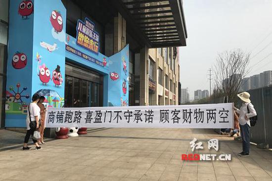胡女士等消费者来到喜盈门建材家具广场，拉起一道维权横幅。