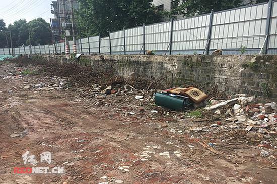  古城墙前堆放着不少的建筑垃圾。 