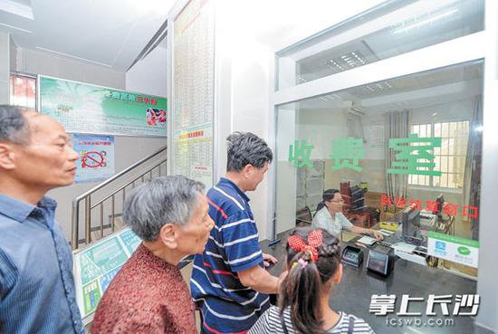 在韭菜园街道社区卫生服务中心医保结算窗口,参保人员正在办理相关业务。