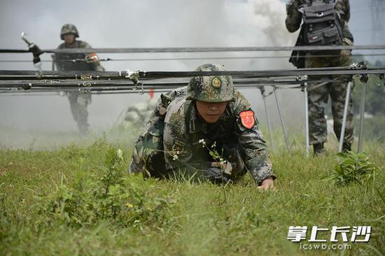 国防科技大学的近千名毕业学员走上演练场,在“炮火硝烟”中领取毕业证。图为演练场上,学员们正通过“敌火力”封锁区。长沙晚报通讯员蒲政烨 孙然 王若平 邓子平摄影