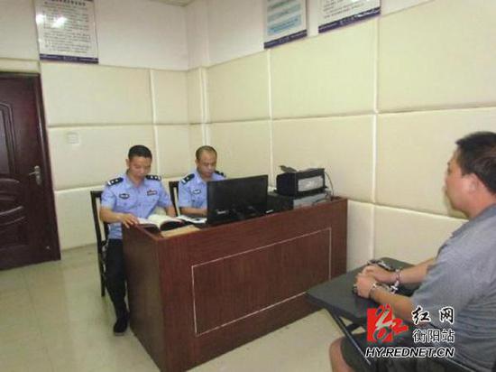 民警对嫌疑犯李某运进行审讯。