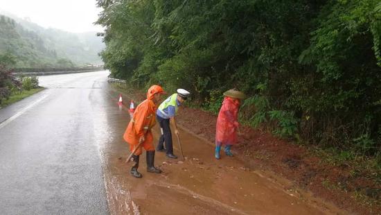 淤泥漫道，民警联合路政队员一点一点清理