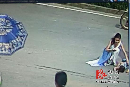 图为女子正在进行紧急施救并报警。