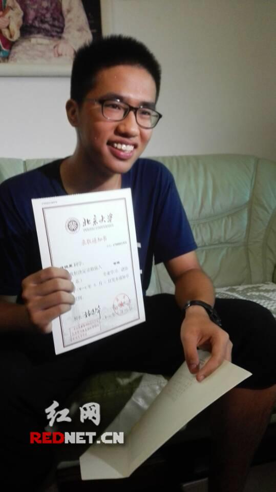 拿着北京大学录取通知书,非常开心。