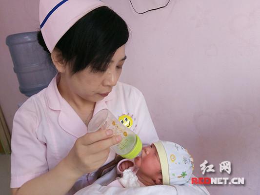 娄底丽人妇产医院的医护人员正在给女婴喂水。