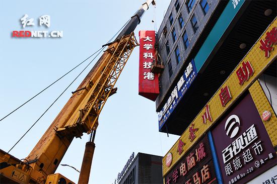8月7日,岳麓区阜埠河路沿线的违规招牌拆除工作也在同时进行,图为施工队员正在拆除一块施工难度较大的违规招牌。