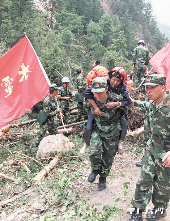 8月9日，救援人员在九寨沟地震灾区转移受灾群众。