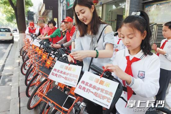 芙蓉区文艺路街道志愿者引导、呼吁规范停放共享单车 。芙蓉区文明办供图