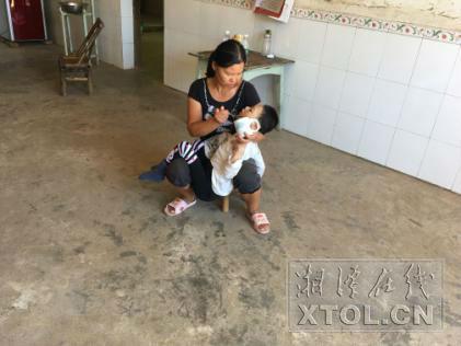 母亲陈灿辉给儿子陈健喂水(记者 刘崇婉 摄)