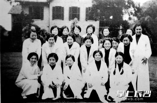 福湘女中学生在做化学实验课前合影,她们穿着统一的白大褂,整洁极了。