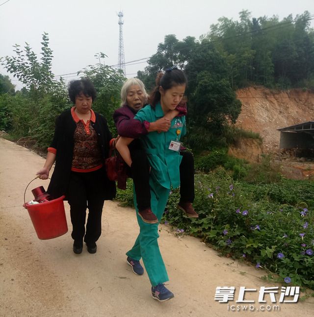 宁乡县中医医院的120急救医生刘畅背起患者赶山路。 (图片来自网络)