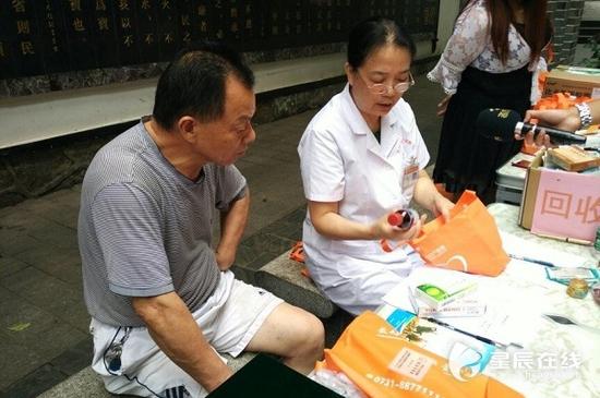 (义诊医生为居民讲解过期药品危害。由通讯员供图。)
