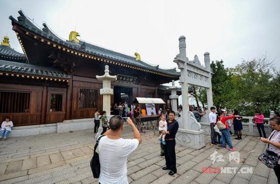 修缮一新的昭山古寺门前游客正在拍照留念，观赏风景。