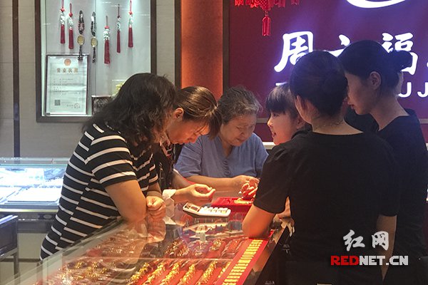 长沙市民易女士(左二)也遇到同样的“套路” ,柜员将易女士叫到一旁商量解决方式,最后给她置换了足克的金耳环。