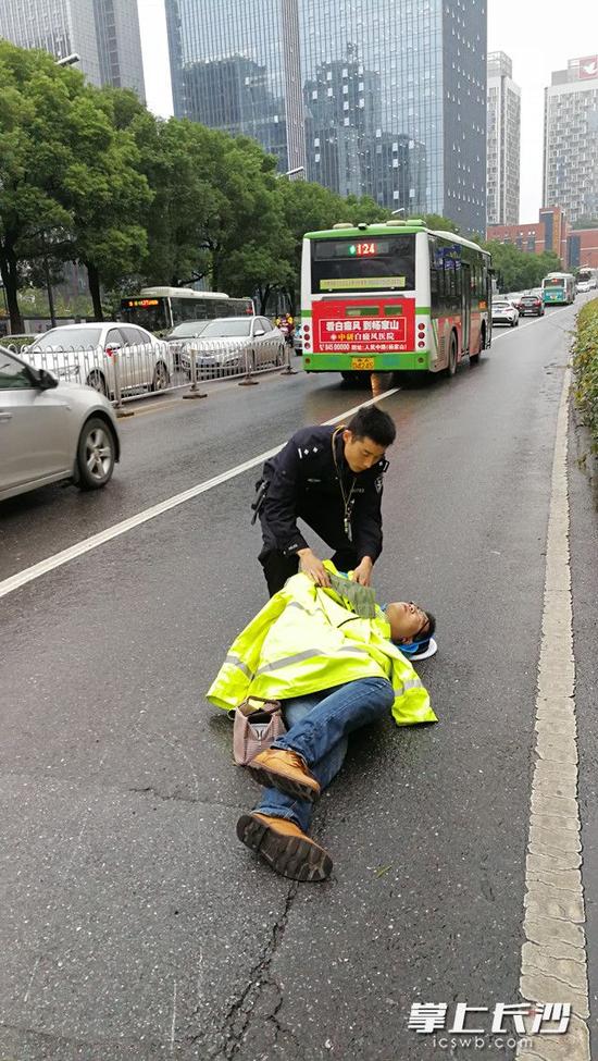 担心伤者受寒，肖亮又脱下了自己的执勤雨衣给他盖在身上。交警供图