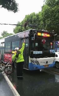 10月18日上午，长沙湘雅路，民警用扫帚托举起垂落的电缆。交警供图