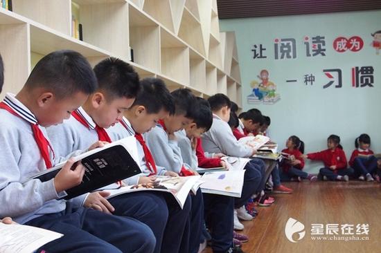 （燕山小学的学生们在阅览室里，无论是取书、还书还是阅读都非常有序。）