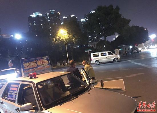 11月1日晚上10点,湘雅路西口一驾校教练车停靠在路边,有市民进行相关咨询。 记者 张洋银 摄