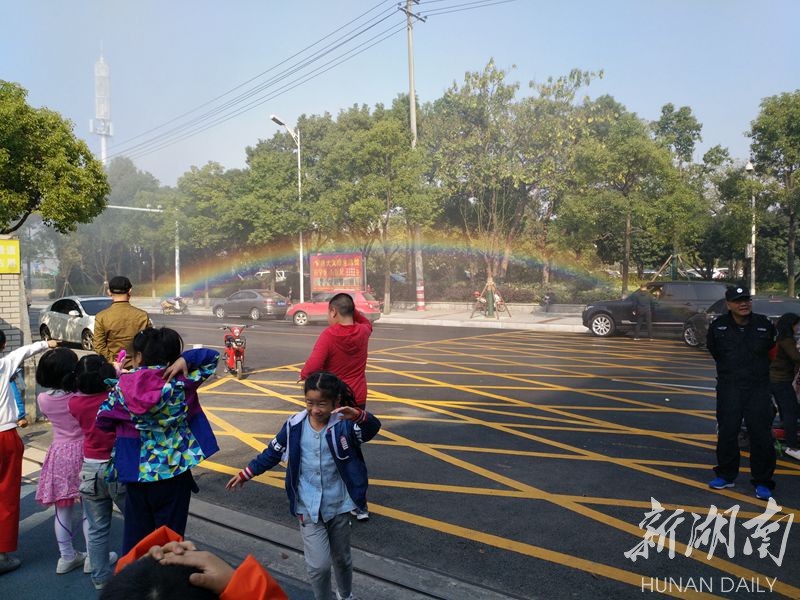 (雾炮洒水车一过,空中留下一道彩虹)