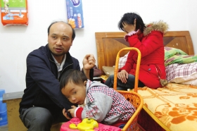 11月12日,长沙县城西小区一出租屋,儿子轩轩(化名)紧靠着谭湘平,床上坐着妻子刘伟平。图/记者华剑