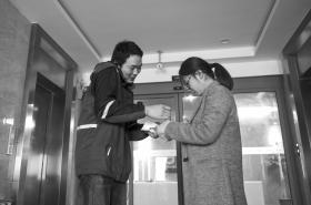 杨宏亮边接电话边等候取件人签字,到下午5:30左右,他一天送了360多个包裹。