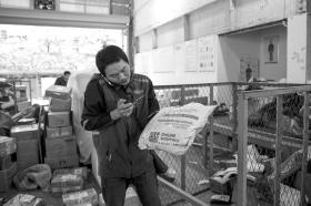 11月13日,杨宏亮在公司内分拣包裹时,接到了客户的催单电话。 组图/记者陈正