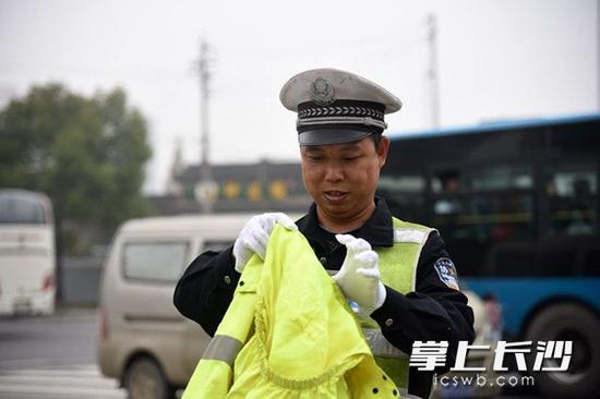 拿到自己的雨衣，协警王震感到心里感到很暖 长沙晚报记者 刘琦摄