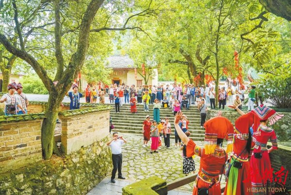 广西壮族自治区河池市宜州区刘三姐故里景区,游客和“刘三姐”对山歌。