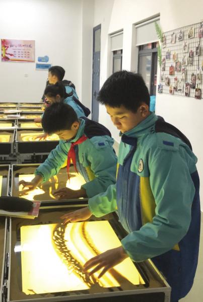 2月18日,长沙开福区浏阳河小学,学生正在上沙画课。图/受访者提供