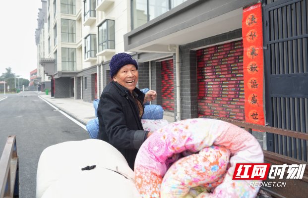 马克海准备搬着被子进新房。
