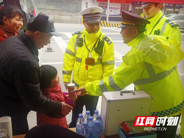 春运期间，长沙县唐田超限检测站公路路政、公安交警给春运返乡的人民群众发放八宝粥、矿泉水等物品。