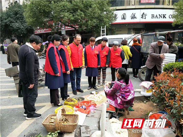 石鼓区潇湘街道司前社区“衡阳群众”志愿者劝导商贩在规定的范围内摆放商品,不占道经营。