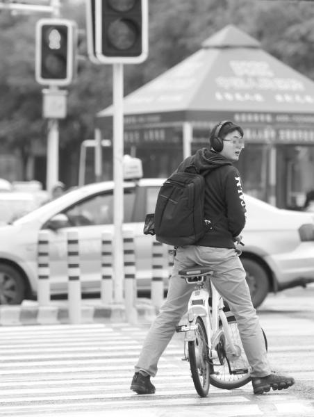 11月18日，长沙韶山路与城南路交会处，骑共享单车的市民在闯红灯时被叫停。　　　图/记者杨旭