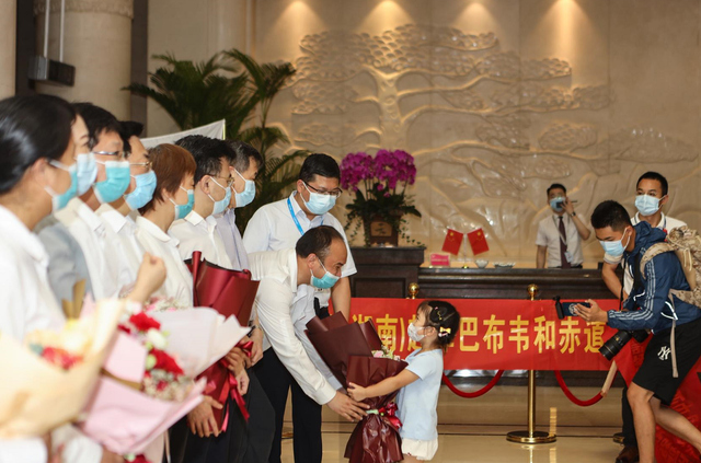 ▲6月22日,长沙黄花国际机场,专家组成员、中南大学湘雅三医院检验科副教授章迪接受女儿的献花。章迪正想和女儿说上两句话,小女孩转身就跑了。