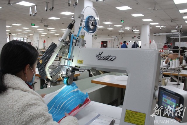 2月8日,衡山县工业园湖南华升金爽纺织服装有限公司生产车间,工人们正在生产防疫物资