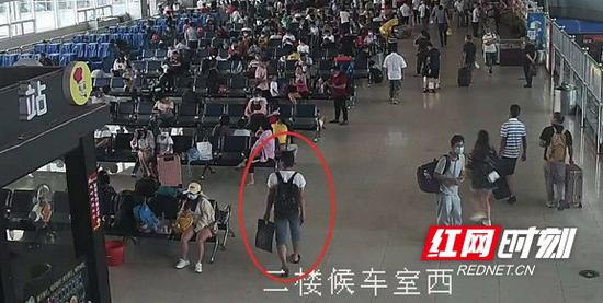 拿着手提袋进入候车室。
