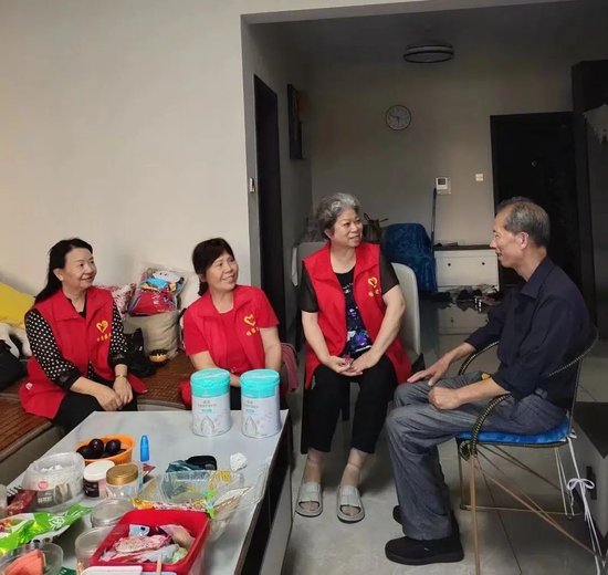 殷自文（左三）与团队成员慰问失独家庭。 受访者供图
