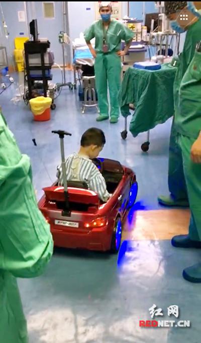 小患者坐着遥控童车进入手术室。唐静霞供图